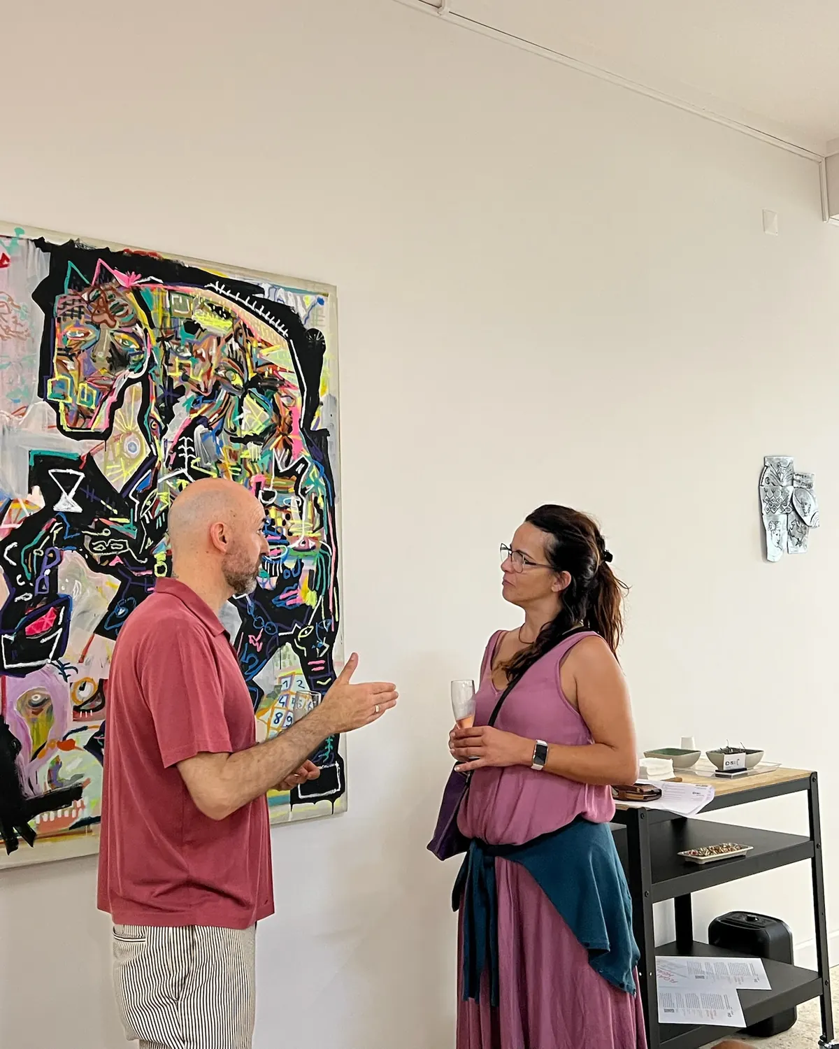 João Soares em conversa com uma visitante, diante de uma pintura