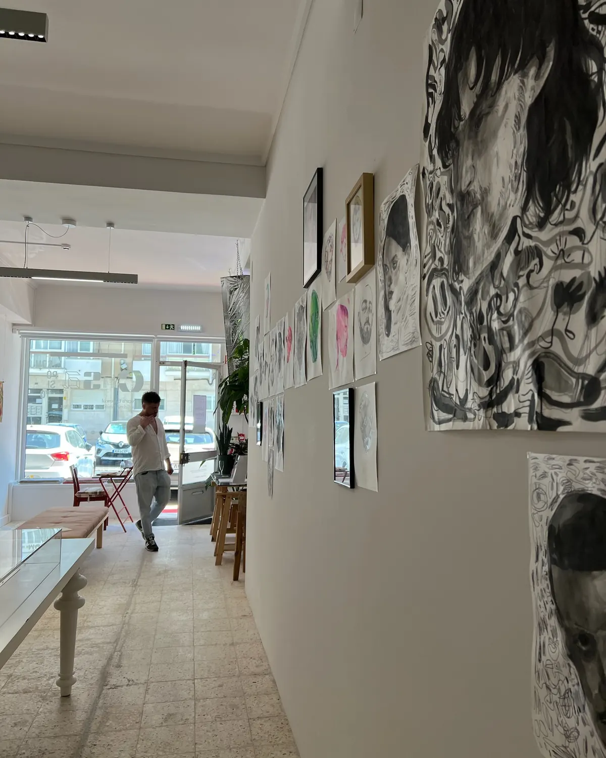Parede da galeria com retratos a tinta e aguarela da exposição Floating Heads
